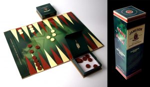 Jameson Whisky - Flaschenbox, die zu einem Backgammon-Spiel wird mit Spielsteinen in Decker und Fuß.